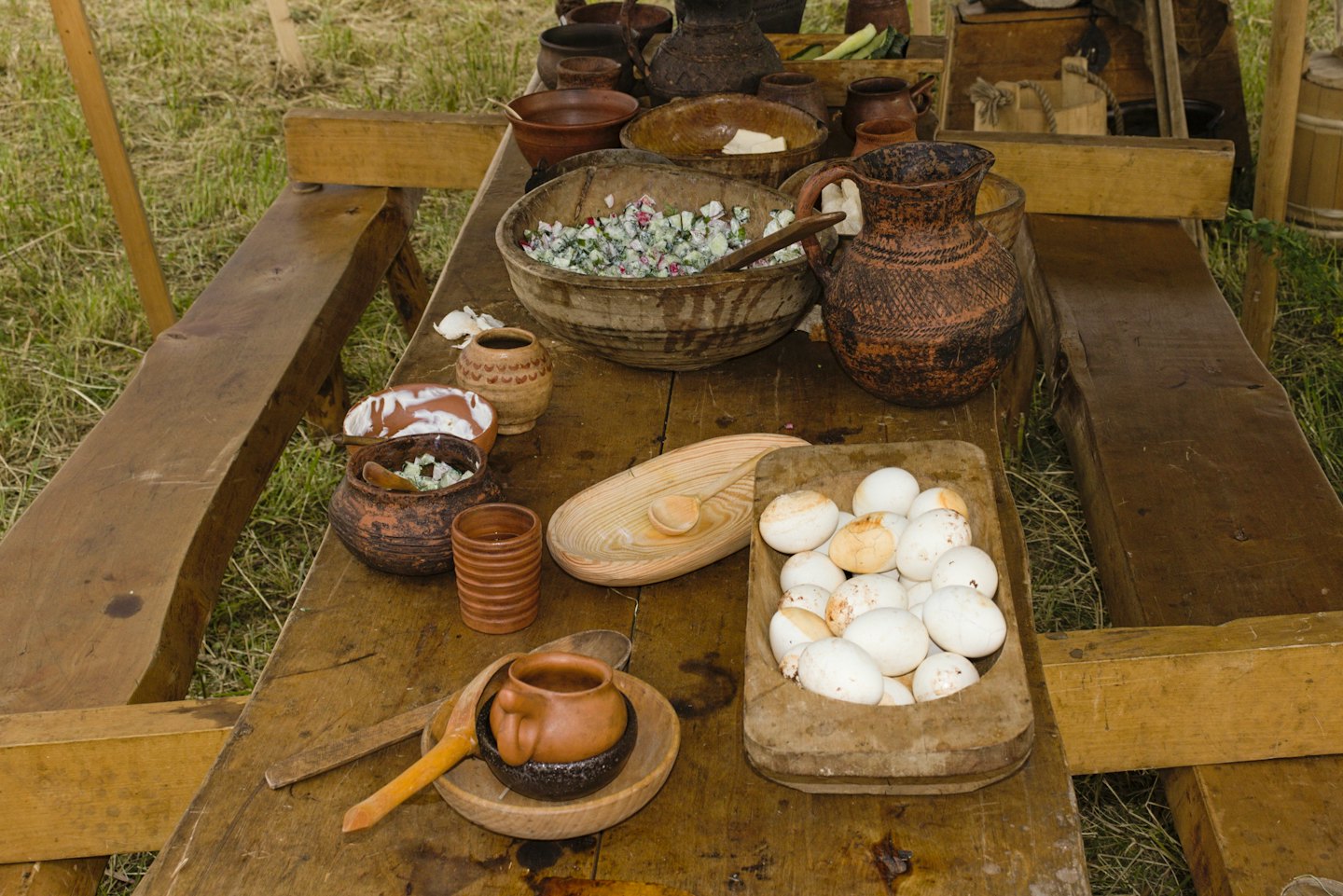 Traditional food and eggs arranged on a long rustic wooden table.